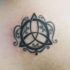 a tattoo design on the back of a woman's shoulder and chest, with two intertwined circles