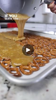 someone is pouring caramel sauce on pretzels in a pan with the words if you serve this