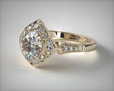 a diamond engagement ring with an oval center surrounded by smaller round brilliant cut diamonds, on a white background