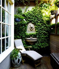 an outdoor patio with a chair, sink and potted plants on the side wall