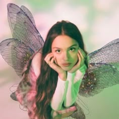 a woman with long hair wearing a green and white fairy costume is posing for the camera