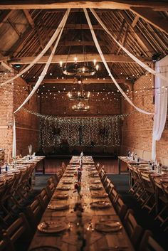 the inside of a barn with tables and chairs set up for an elegant wedding reception