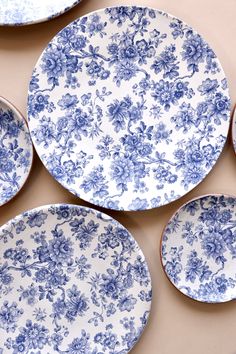 four blue and white plates sitting on top of each other