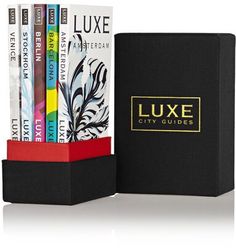 a black box with four books in it and a red ribbon around the bottom that says luke city guides