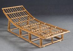 a bamboo chaise lounge chair sitting on top of a gray floor