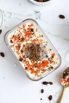 an ice cream dish with carrots and granola in it on a marble surface