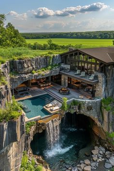 an aerial view of a house with a pool and waterfall in the middle of it