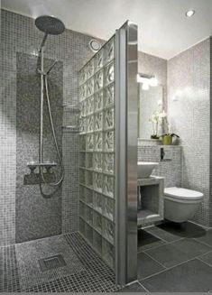 a bathroom with gray tile and glass walls