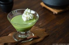 a green drink with whipped cream on top