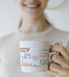 a woman holding a coffee mug with diagrams on it