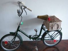 a bike with a basket on the front and handlebars is parked against a wall