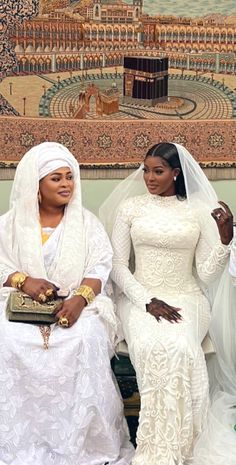 two women in white dresses sitting next to each other