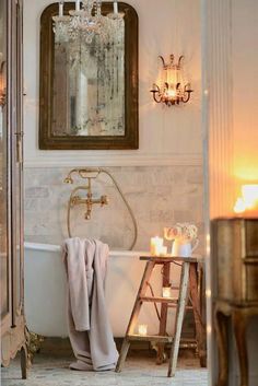 a bathroom with a chandelier, mirror and bathtub in the middle of it