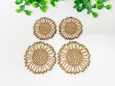 three wooden coasters sitting on top of a white table next to green plant leaves