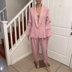 The Gorgeous Blush Pink Blazer Pant Suit Is Perfect For Work Or Evening Wear. The Suit Is Made Of 95% Polyester & 5% Spandex. The Material Has A Slight Stretch. Single Button Front Closure On The Blazer. Sleeves Are Gathered To Give A More Stylish Appeal. Pants Have A Hook & Eye Closure With A Front Zipper. The Pants Have A Tie At The Ankles. The Suit Has No Pockets. Fitted Pant Set With Pockets For Spring, Spring Solid Color Pant Set For Work, Spring Workwear Pant Set, Pink Long Sleeve Pant Set For Work, Fitted Pant Set For Workwear In Spring, Fitted Pant Set For Spring Workwear, Spring Tailored Long Sleeve Pantsuit, Spring Solid Color Long Sleeve Pantsuit, Fitted Pant Set For Office In Spring