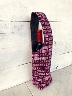 a wine bottle holder made out of fabric with words on it and a corkscrew