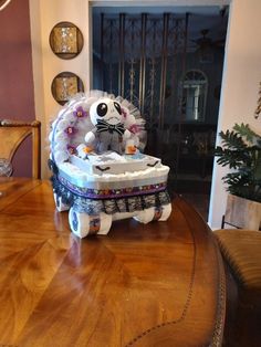 a cat figurine sitting on top of a wooden table in front of a doorway