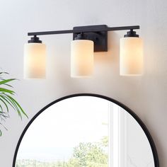 a bathroom light with three lights on it and a mirror in front of the wall