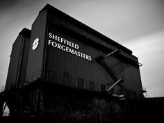 a black and white photo of a building with the words sheffield forgemasters on it