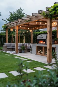 an outdoor kitchen and grill area with lights on the roof, surrounded by green grass