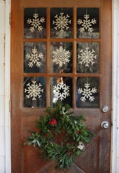 a door decorated with snowflakes and greenery