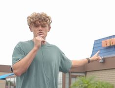 a young man holding a cell phone to his ear while standing in front of a building