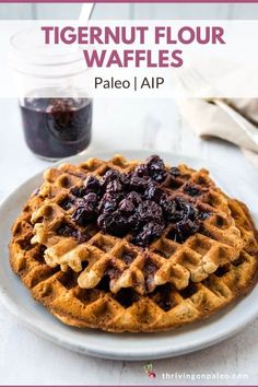 a close up of a waffle on a plate with blueberry compote