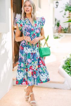 Welcome in the bright days ahead with this navy blue floral midi dress! Feel free to make a statement and stand out with the bold and bright floral print while the classic midi silhouette and flirty ruffled cap sleeves keep you looking timelessly chic. Perfect for any occasion and guaranteed to add a little extra sunshine to any wardrobe! This midi dress features ruffled cap sleeves, pockets, a split v-neckline, tiered body, and a colorful floral print.  Material has no amount of stretch.Cam is Navy Blue Floral Dress, Blue Floral Midi Dress, Floral Cocktail Dress, Black Tie Dress, Long Sleeve Outerwear, Two Piece Swimwear, Floral Blue Dress, Floral Dresses, Romantic Style