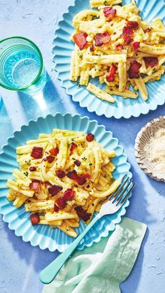 two plates with pasta and bacon on them