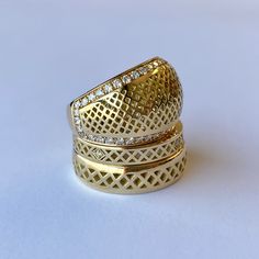 two gold rings with diamonds on them sitting next to each other