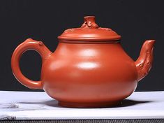 an orange teapot sitting on top of a table