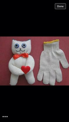 two knitted gloves with eyes, one wearing a bow tie and the other holding a heart