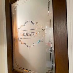 a glass door with the word laborator on it in front of a white wall