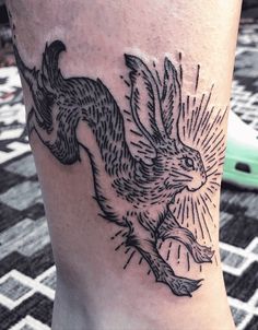 a tattoo on the leg of a person with a bird in it's hand