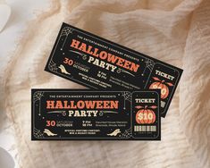 two halloween tickets sitting on top of a table