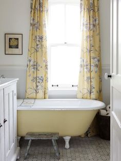 a bath tub sitting next to a window in a bathroom