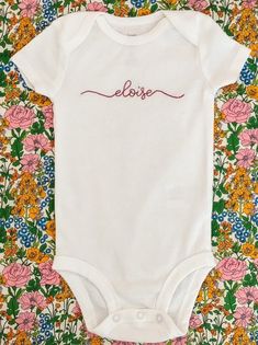 "This made to order, hand embroidered bodysuit is the perfect way to welcome home a new baby or give a custom gift. Each white Onesie® is personalized with baby's name using a modern, clean script. This makes a unique baby gift and future keepsake once outgrown. Each of the Onesies® is available in either short sleeve (SS) or long sleeve (LS). Because each Onesie® is hand embroidered, no two are identical and there will be variations across each item making it completely unique. Personalize each Hand Embroidery Onesie, Embroidered Onesie Girl, Hand Embroidery Names, Embroidery Baby Gifts, Onesie Embroidery, Baby Name Onesie, Personalized Onesies, Embroidered Baby Clothes, Name Onesie