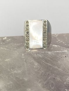 "Mother of Pearl ring marcasites sterling silver women Size. 8.75 Weight 11g Length. 7/8\" Width 5/8\" Narrowest part of band 3/16\" Free Shipping & Free Postal Insurance Delivered in a Gift Box If you do not want the ring polished and want to leave the natural patina please let me know at the time of purchase as I do polish rings before I ship rings out. Thanks Free First Class shipping and postal insurance is included. If you want to upgrade to priority kindly pay an additional fee to do s Classic Marcasite Jewelry For Anniversary, Marcasite Gemstone Ring For Anniversary, Marcasite Ring For Anniversary, Silver Marcasite Jewelry Stamped 925, Silver Marcasite Ring, Silver Marcasite Jewelry With Gemstone, Marcasite Ring Stamped 925, Marcasite Anniversary Rings Stamped 925, Silver Marcasite Ring With Gemstone