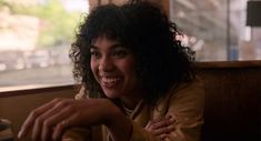 a smiling woman sitting at a table in a restaurant