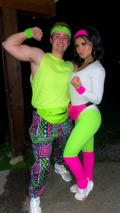 a man and woman dressed up in neon clothing posing for a photo with each other