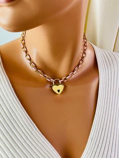 This is a very cool gold stainless steel chunky chain choker necklace with a working heart padlock. Super cute you're going to love this. These chain links have pink enamel which makes so unique. Links measure 11 X8 mm. Heart padlock comes with two keys and measures 28X 22 mm. Model is wearing a 15 inch length. Please choose your desired length. It's best to measure your neck prior to ordering to determine the length you want. Comes in a gift box ready to present.  Please note the chain is stain Rose Gold Chunky Chain Necklace As A Gift, Metal Jewelry With Lock, Trendy Heart Necklace With Chunky Chain For Valentine's Day, Chunky Chain Jewelry For Valentine's Day Gift, Chunky Chain Necklace For Valentine's Day Gift, Trendy Chunky Chain Heart Necklace For Valentine's Day, Pink Chunky Chain Necklace For Gift, Valentine's Day Chunky Chain Necklace Gift, Valentine's Day Gift Chunky Chain Jewelry