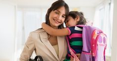 a woman holding a child in her arms and smiling at the camera while wearing a backpack