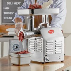 a man is preparing meat in a commercial meat grinder