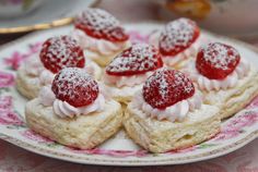 strawberry shortcakes with whipped cream and powdered sugar on a pink floral plate