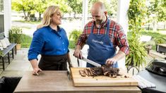 a man and woman are preparing food on a grill