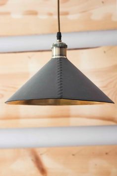 a metal light hanging from a wooden ceiling