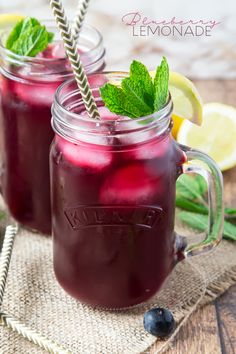 two mason jars filled with blueberry lemonade on top of a burlly cloth