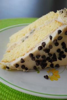 a slice of cake with white frosting and chocolate chips