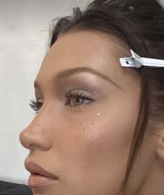 a close up of a woman with scissors in her hair