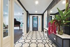 the hallway is decorated in black and white with a large vase full of flowers on it